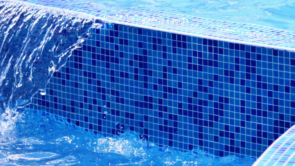 Shot of a pool waterfall and blue pool tile